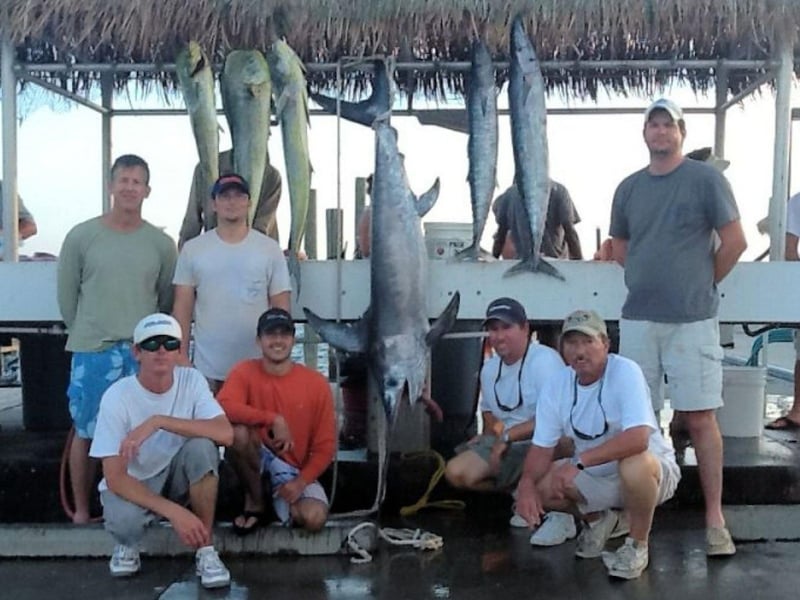A group on the dock with their catches in Pensacola Beach, Florida