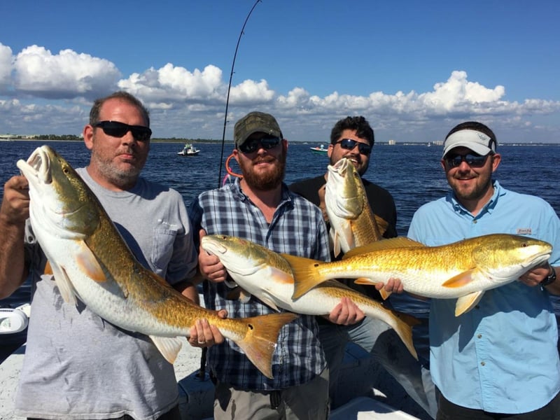A group showing off their catch aboard Reel Addiction in Pensacola Beach, Florida