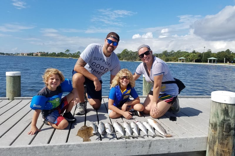 A family on the dock with their cathces from Cant Quit Fishin