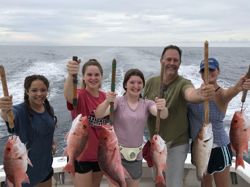 A family on King of Kings holding their catches
