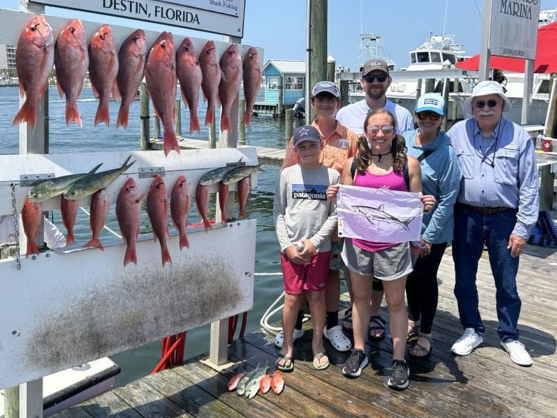 A family on the dock in front of their catches