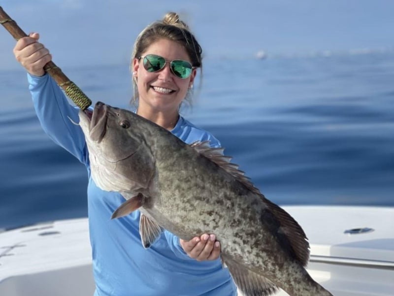 A woman displaying her fish on board Strictly Business in Santa Rosa Beach, Florida