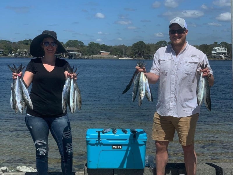A group with their fish on the shore in Santa Rosa Beach, Florida