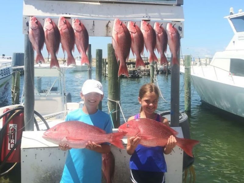 Two children with their catches on the dock in Destin, Florida