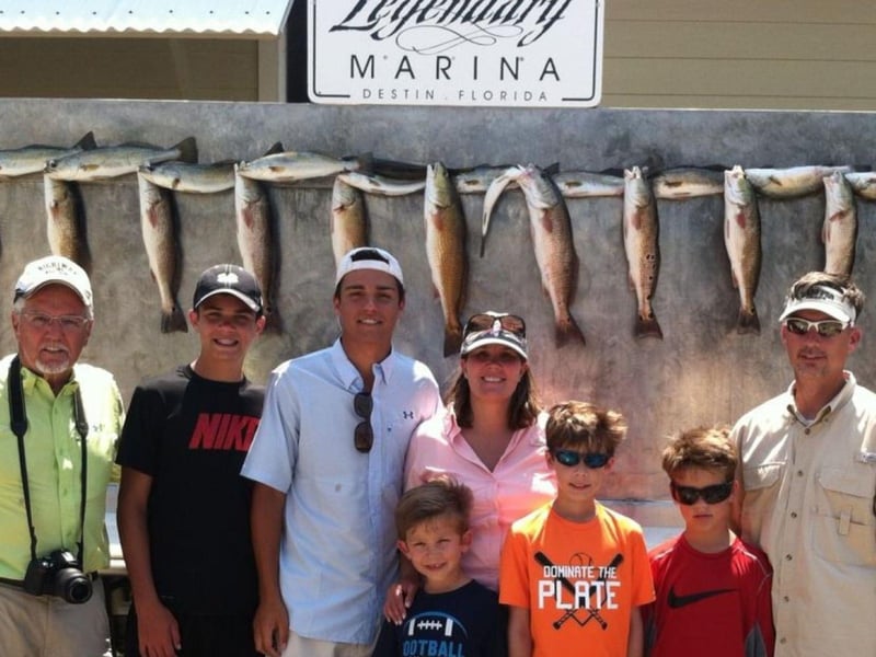 A family on the dock with their catch from Last Cast Charters in Destin, Florida
