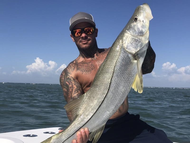 A man showing off his catch with Calibrated Fishing Charters in Sarasota, Florida