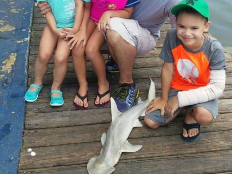 A kid on the dock with their catch from Siesta Key Sport Fishing Charters