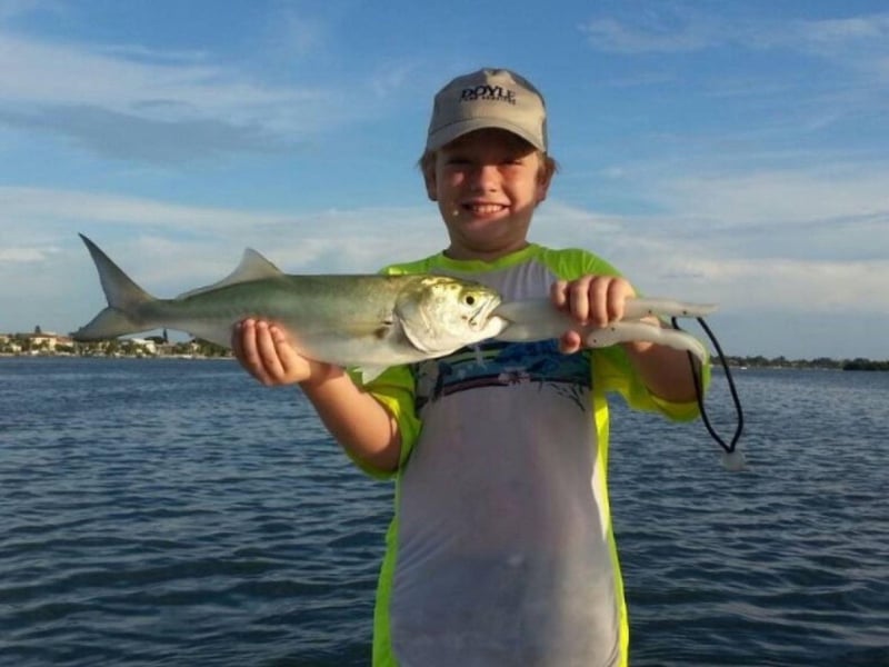 An angler showing off his catch on the boat
