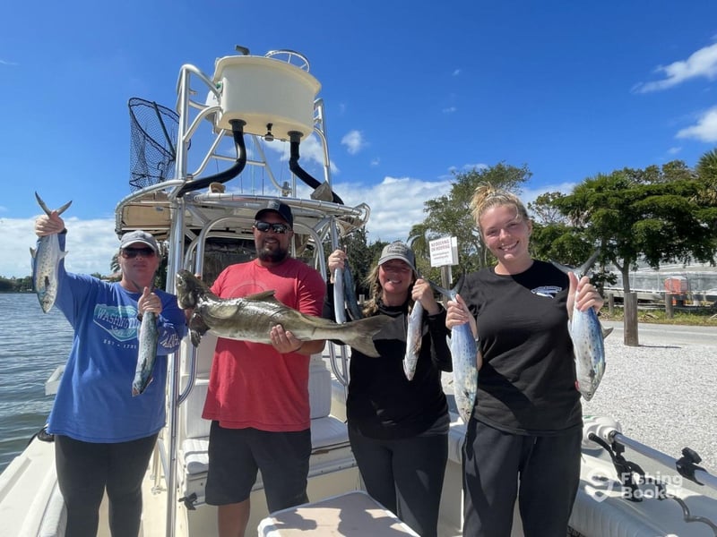 A group showing off their catch on the back of the boat