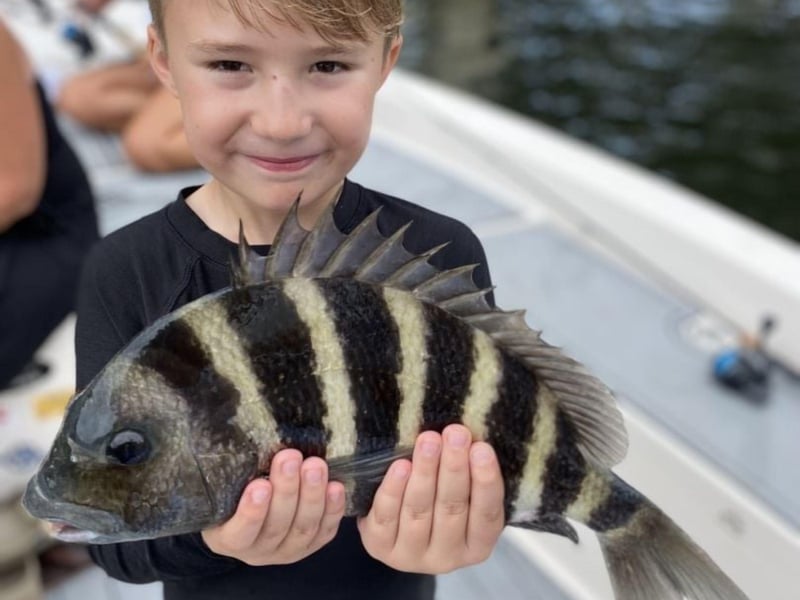 A child showing off his catch with Stellar Action Fishing Charters