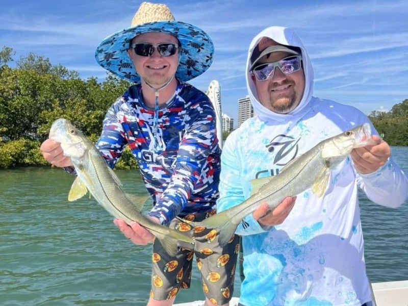 Two guests with their catch on the boat with Windward Fishing Charters