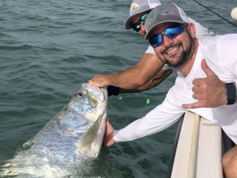 Two men fishing off the side of the boat in Sarasota, Florida