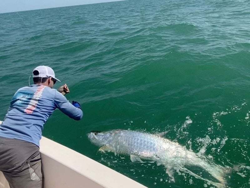 A man fishing off the side of the boat with James Gibson Charters LLC