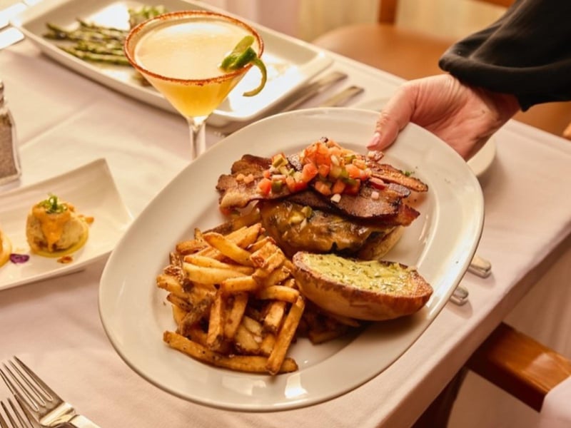 A server placing an entree onto a table at Jacksons Restaurant