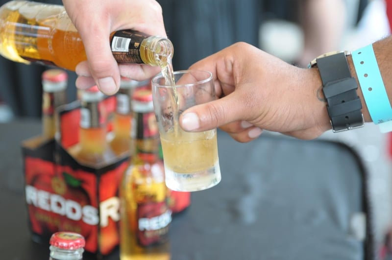 498929 Baytownebeerfestcloseupofhandsholdingbottleandsampleglass