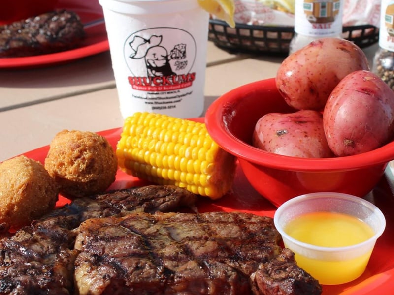 A steak with potatoes, hushpuppies and corn at Shuckums Oyster Pub  Grill