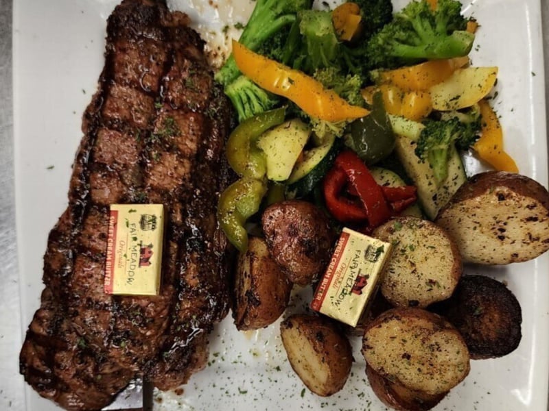 The 12 oz New York Strip with  vegetables and potatoes at Old Bay Steamer in Fort Walton Beach, Florida