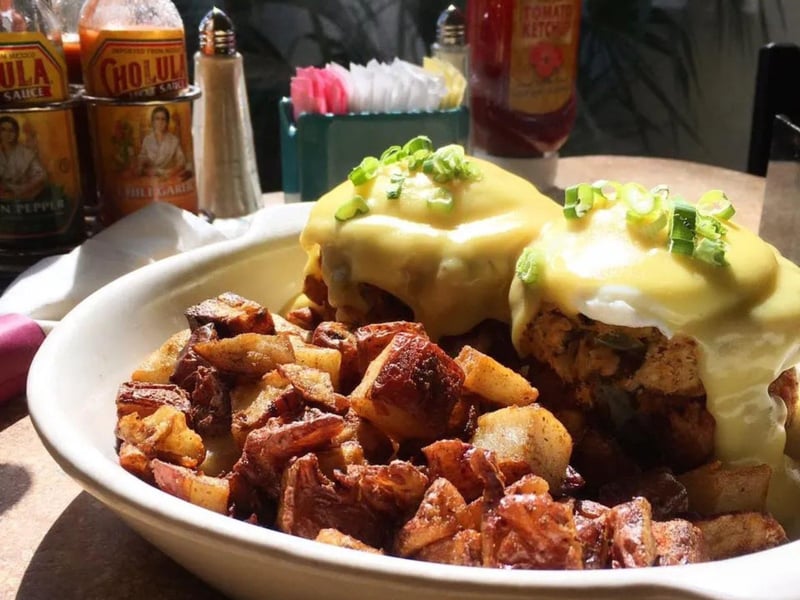 An eggs benedict with homestyle potatoes