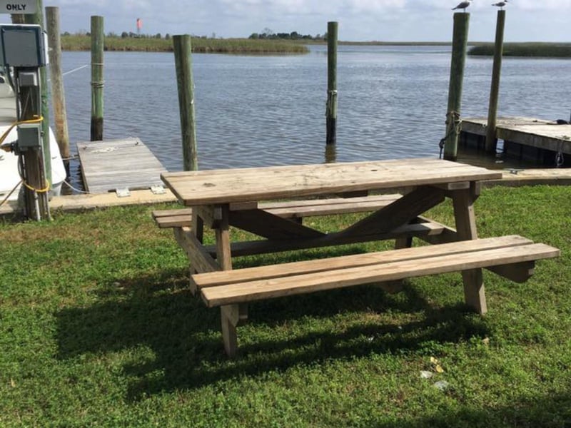 A picnic table by the water at Up the Creek Raw Bar