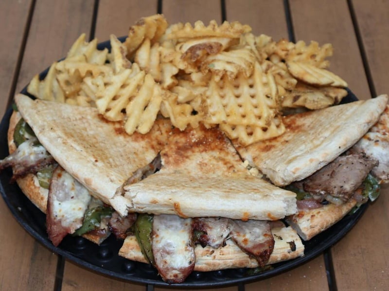 A steak sandwich with waffle fries