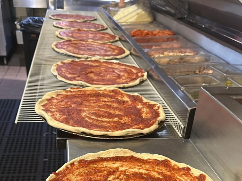 Pizzas on the line with sauce at Brunos Pizza