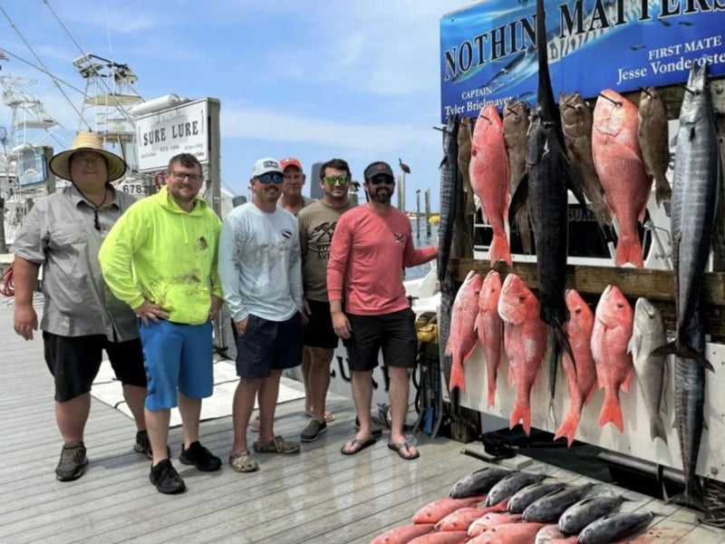 A group with their catches on the dock