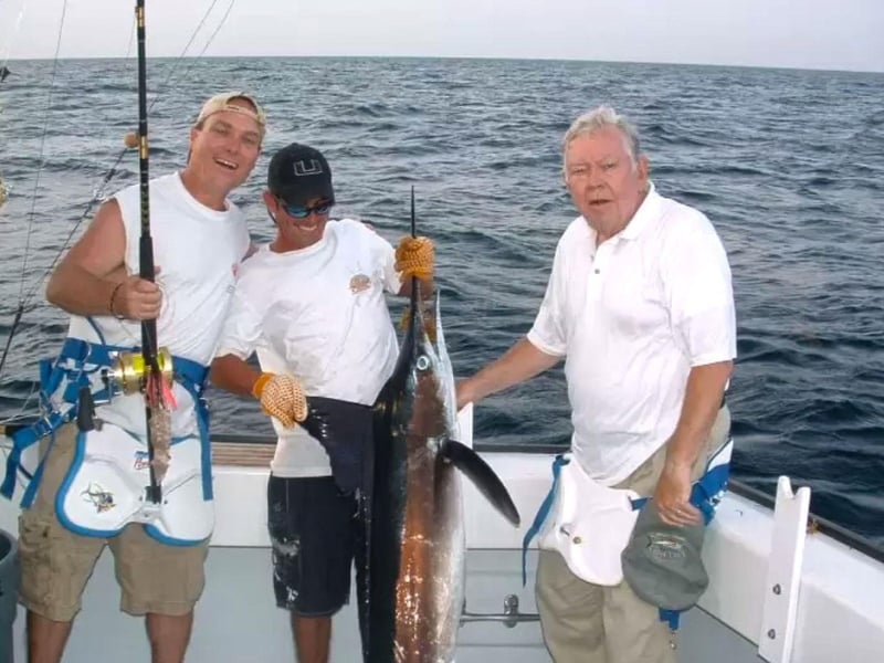 A group showing off their catch on the water