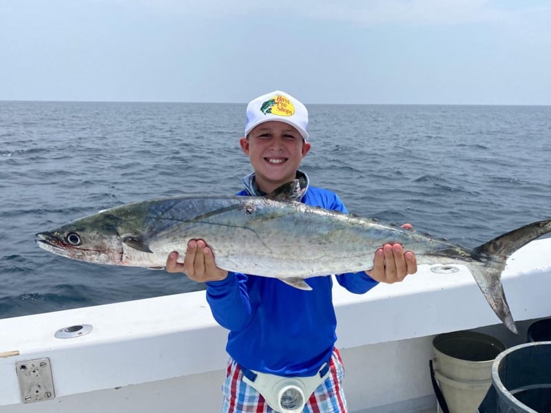 A kid showing off his catch on the water in Destin, Florida