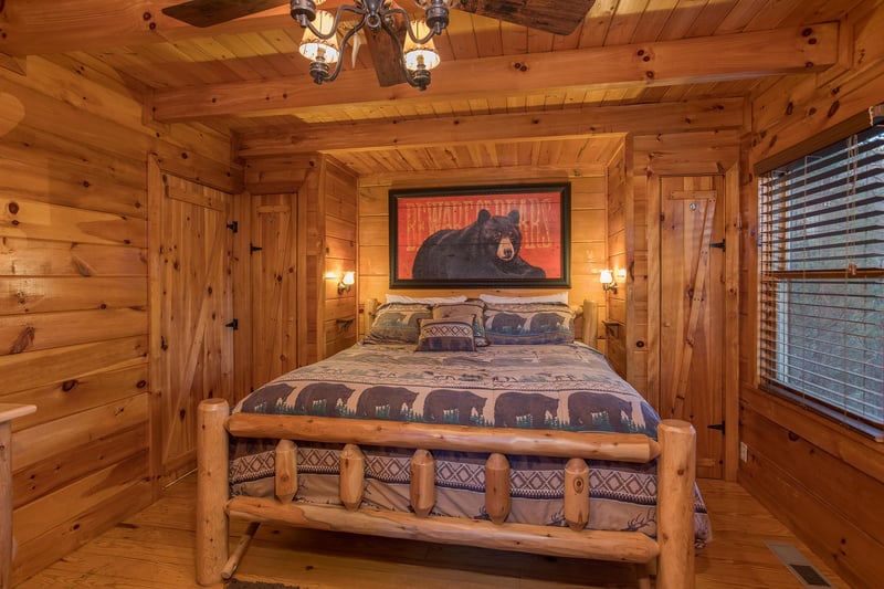 king sized log bed in the master bedroom at always  forever a 1 bedroom cabin rental located in pigeon forge