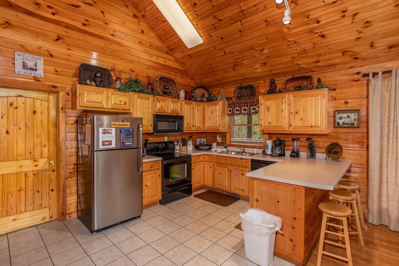 Kitchen with stainless appliances and counter seating for three at Bear Country, a 3bedroom cabin rental located in Pigeon Forge