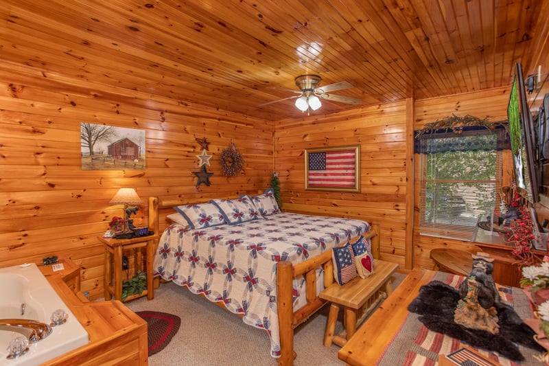 Bedroom with a kingsized log bed at Bear Country, a 3bedroom cabin rental located in Pigeon Forge