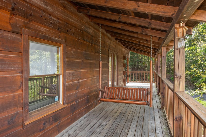 Swing on a covered porch at Bear Country, a 3bedroom cabin rental located in Pigeon Forge