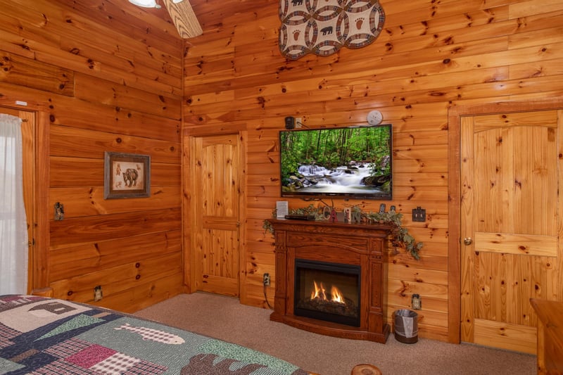 Bedroom with electric fireplace and television at Bear Country, a 3bedroom cabin rental located in Pigeon Forge