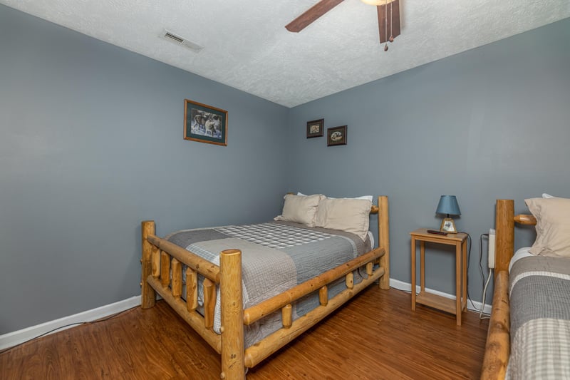 Bedroom with two beds, a table, and lamp at Wildlife Retreat, a 3 bedroom cabin rental located in Pigeon Forge