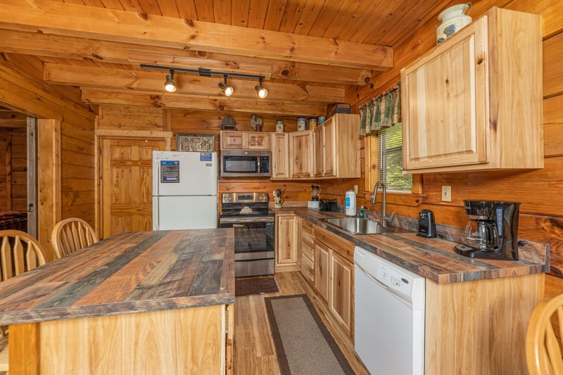 Kitchen with white and stainless appliances at Walkin To Gatlinburg, a 2 bedroom cabin rental located in Gatlinburg