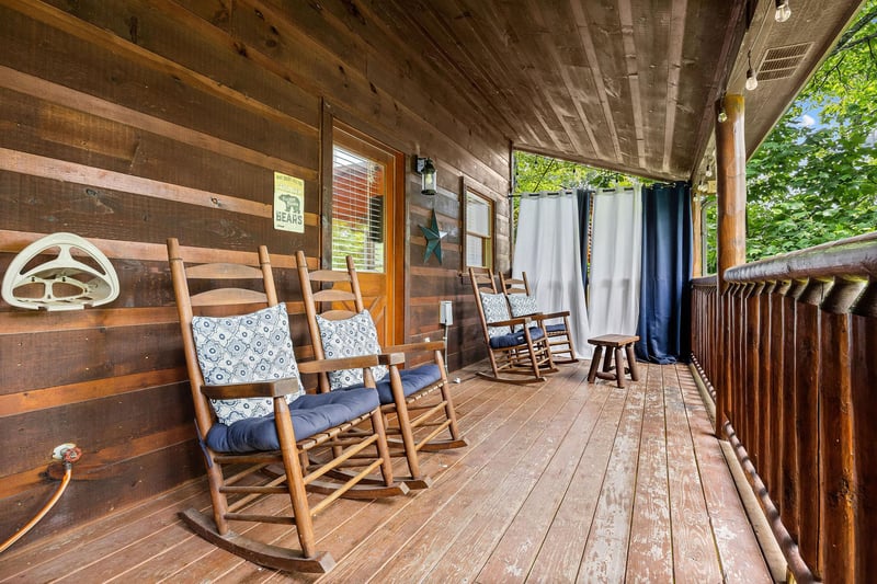 Rocking chairs on a covered deck at Honey Bear Haven, a 1 bedroom cabin rental located in Pigeon Forge