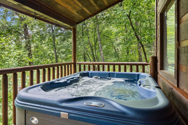 Hot tub on a covered deck at Honey Bear Haven, a 1 bedroom cabin rental located in Pigeon Forge