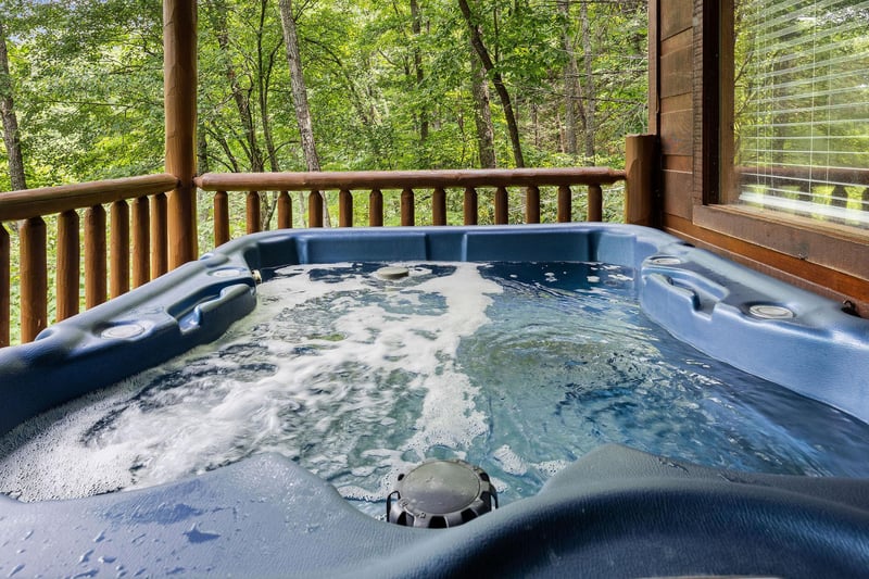 Hot tub on a covered deck at Honey Bear Haven, a 1 bedroom cabin rental located in Pigeon Forge