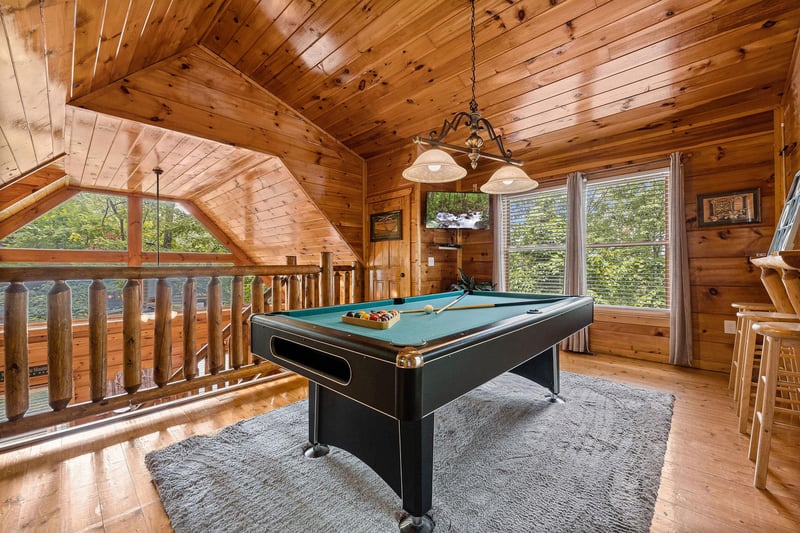 Pool table and TV in the game space at Honey Bear Haven, a 1 bedroom cabin rental located in Pigeon Forge