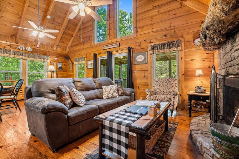 Living room with fireplace, tv, deck access, and vaulted ceilings at Cloud 9, a 1bedroom cabin rental located in Pigeon Forge