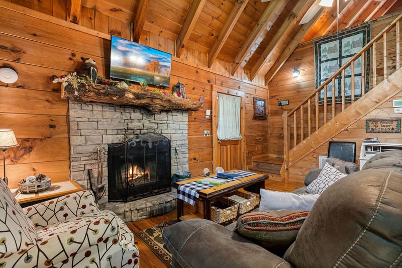 Living room with fireplace, tv, and deck access at Cloud 9, a 1bedroom cabin rental located in Pigeon Forge