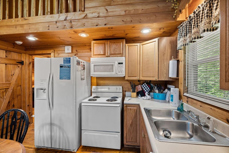 Kitchen with white appliances at Cloud 9, a 1bedroom cabin rental located in Pigeon Forge