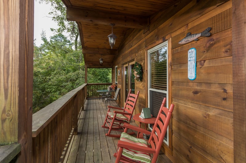 Rocking chairs on a covered deck at Birds Eye View, a 2bedroom cabin rental located in Gatlinburg