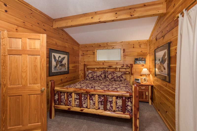 Bedroom with a log bed, night table, and lamp at Birds Eye View, a 2bedroom cabin rental located in Gatlinburg