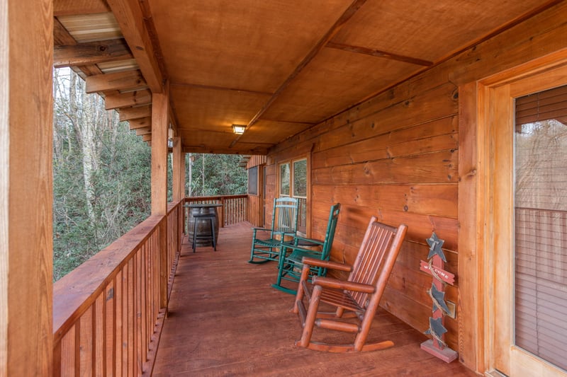 Covered deck with rocking chairs at Moonshiners Ridge, a 1bedroom cabin rental located in Pigeon Forge