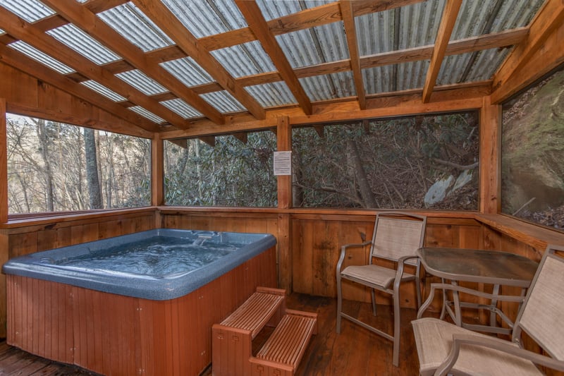 Hot tub on a screened, covered porch at Moonshiners Ridge, a 1bedroom cabin rental located in Pigeon Forge