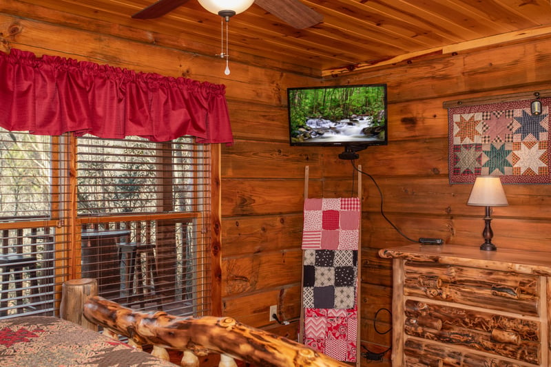 Dresser and TV in a bedroom at Moonshiners Ridge, a 1bedroom cabin rental located in Pigeon Forge