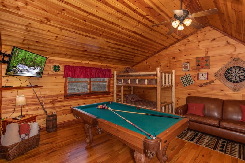 Loft with a pool table, TV, and bunk beds at Moonshiners Ridge, a 1bedroom cabin rental located in Pigeon Forge