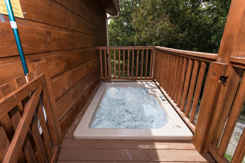 Sunken hot tub on a deck at Cedar Creeks, a 2bedroom cabin rental located near Douglas Lake