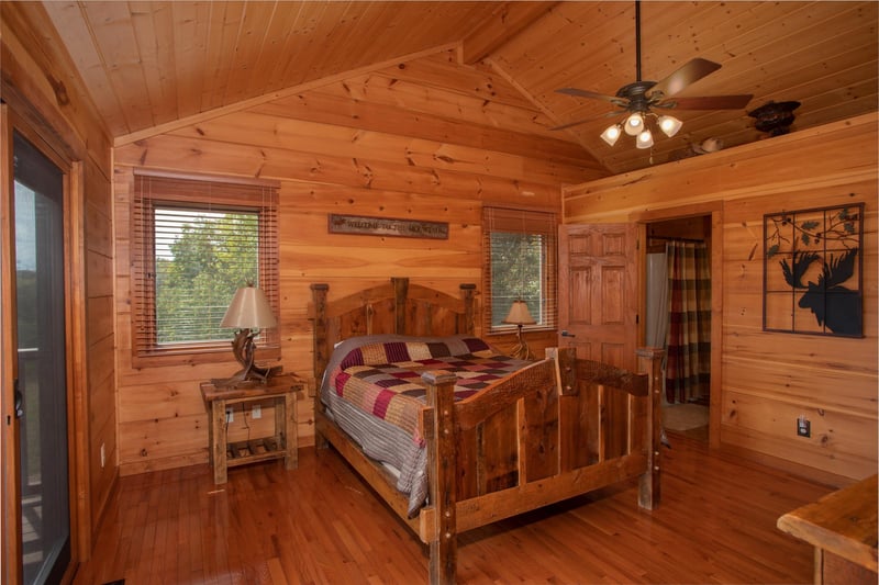 Queensized wooden bed in a bedroom with vaulted ceiling at Cedar Creeks, a 2bedroom cabin rental located near Douglas Lake